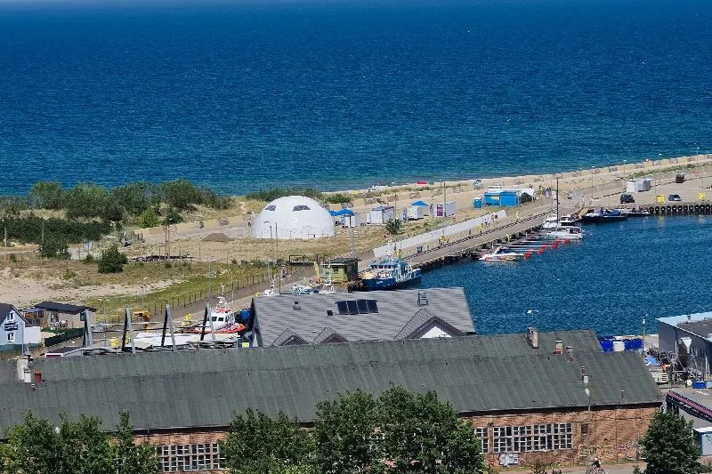 Widok z wieży Domu Rybaka na hale portowe, nabrzeże z jachtami i morze za wydmą