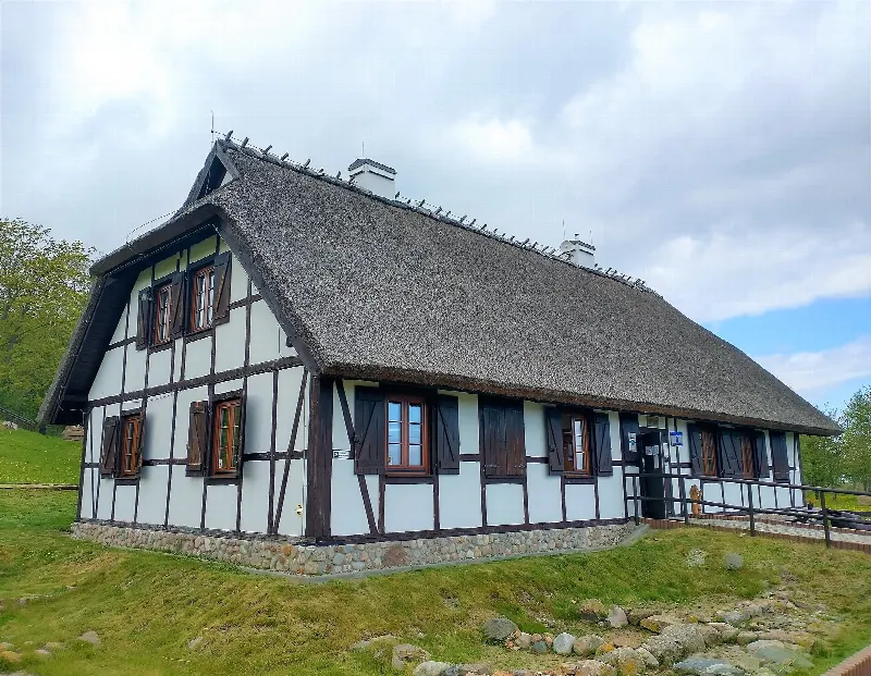 Kaszubska chata z trzcinowym dachem i szachulcowymi ścianami, w której mieści się ekspozycja archeologiczna parku w Rzucewie