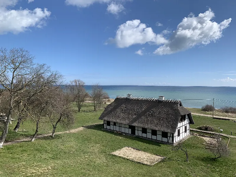 Chata kaszubska na Cyplu Rzucewskim widziana z punktu widokowego, w tle Zatoka Pucka