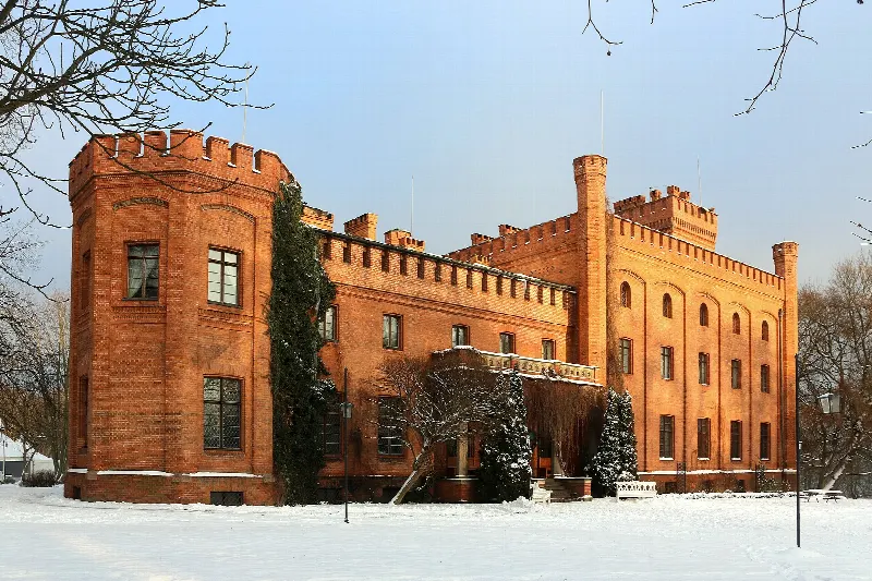 Boczna elewacja pałacu w Rzucewie z okrągłą basztą, zimą w śniegu