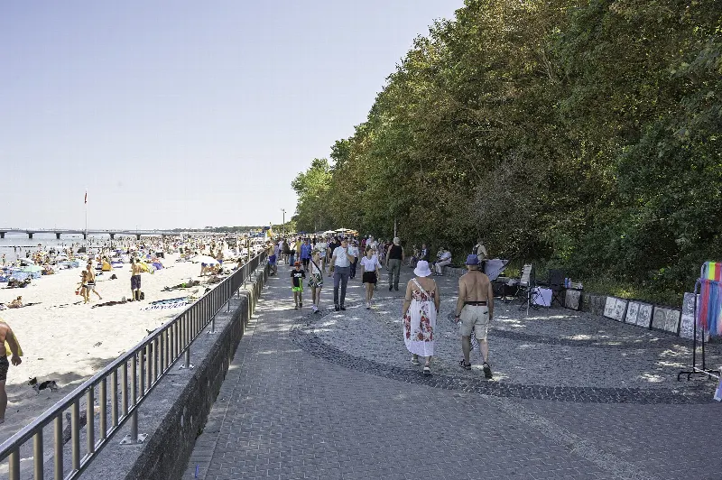 Bulwar Jana Szymańskiego w Kołobrzegu, promenada wzdłuż szerokiej plaży z molo w oddali
