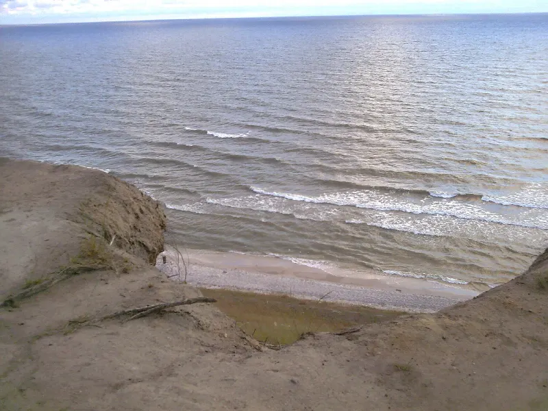 Osypująca się krawędź klifu w Jastrzębiej Górze i wąska plaża pod nim