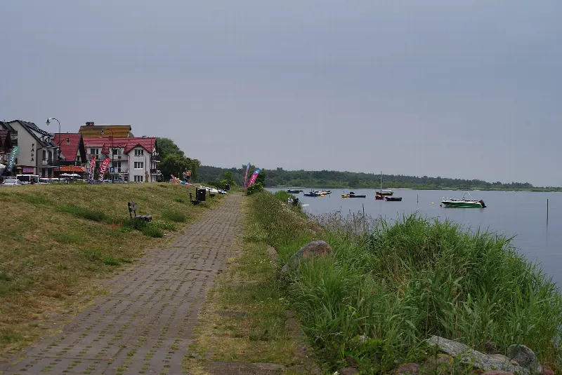 Bulwar i ścieżka nad brzegiem Zatoki Puckiej w Chałupach z łódkami na wodzie